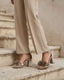 Beige platform sandals with flowers and a chunky heel.