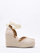 Sandalias de cuña en yute trenzado con cintas al tobillo.