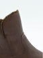 Botín plano de mujer en piel marrón, caña media, con interior efecto borreguito y suela negra gruesa antideslizante.