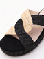 Sandalias planas de rafia con tiras cruzadas en negro y beige. Diseño cómodo, ligero y versátil.