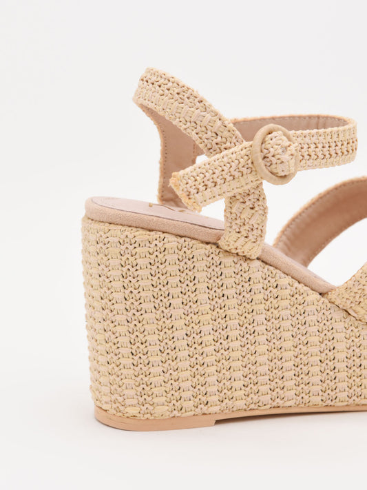 Sandalias de cuña en rafia beige con plataforma y tiras cruzadas. Elegantes, cómodas y versátiles.