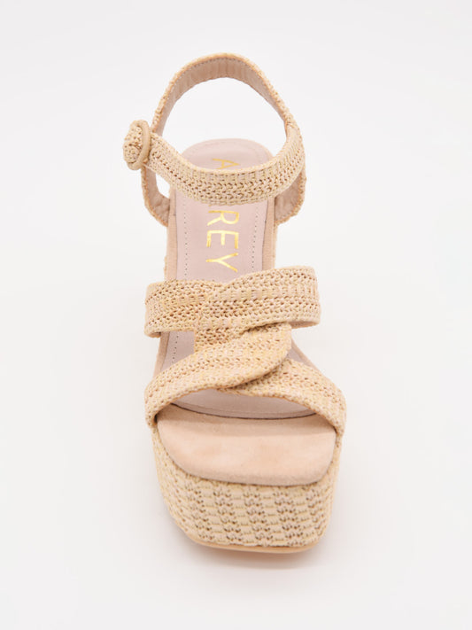 Sandalias de cuña en rafia beige con plataforma y tiras cruzadas. Elegantes, cómodas y versátiles.