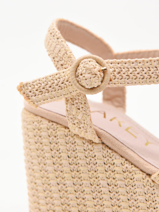 Sandalias de cuña en rafia beige con plataforma y tiras cruzadas. Elegantes, cómodas y versátiles.