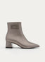 Stivaletto in pelle con tacco geometrico e decorazione sul gambale.