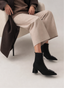 Black ankle boot with wide heel, animal print, and buckle.