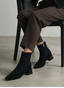 Black ankle boot with wide heel and patent toe.