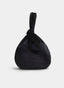 Bolso de mano AZAREY en color negro, de silueta redondeada y flexible, con acabado aterciopelado. Presenta una amplia asa de muñeca integrada y un elegante detalle de nudo en la parte superior.