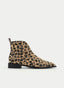 Botín plano de mujer AZAREY con estampado animal print tipo leopardo, punta fina y detalle de tachas metálicas plateadas. El diseño combina textura, contraste y un aire western urbano, con trasera en tono marrón oscuro y cierre lateral con cremallera para mayor comodidad. Un botín con personalidad, ideal para elevar looks de otoño-invierno con denim, vestidos midi, pantalones rectos o prendas básicas de estilo casual chic.