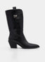 Bota cowboy de mujer en color negro con caña media-alta, puntera afilada y tacón ancho inclinado. Presenta tirador superior con detalle metálico decorativo, cremallera lateral visible y silueta western de líneas limpias y sofisticadas.