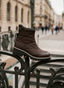 Botines de mujer AZAREY en color marrón con acabado acolchado, caña al tobillo y suela track en contraste. Su diseño combina comodidad, protección y estilo urbano, ideal para los looks de otoño-invierno. La imagen resalta el volumen del botín, el detalle de pespuntes y la suela dentada, creando un modelo versátil para diario, viajes o conjuntos casuales con un toque actual.
