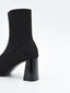 Botín calcetín negro de mujer, de caña elástica ajustada, con tacón ancho cuadrado y punta fina.