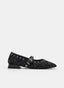 Zapato tipo mercedita plana en animal print negro, negro y marrón. Presenta punta fina, tira negra sobre el empeine con hebilla metálica, tachuelas decorativas alrededor del escote y tacón bajo negro.