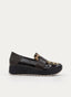 Mocasín de mujer en color negro con cuña de plataforma y suela dentada clara. Presenta empeine con estampado leopardo, antifaz ancho en tono oscuro, puntera redondeada brillante y talón liso en contraste.