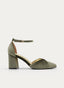 Zapato de salón femenino en color verde oliva, de silueta estilizada y punta fina. Presenta laterales abiertos, detalle plisado en el empeine, talón cerrado, tacón bloque ancho y pulsera ajustable al tobillo con hebilla.